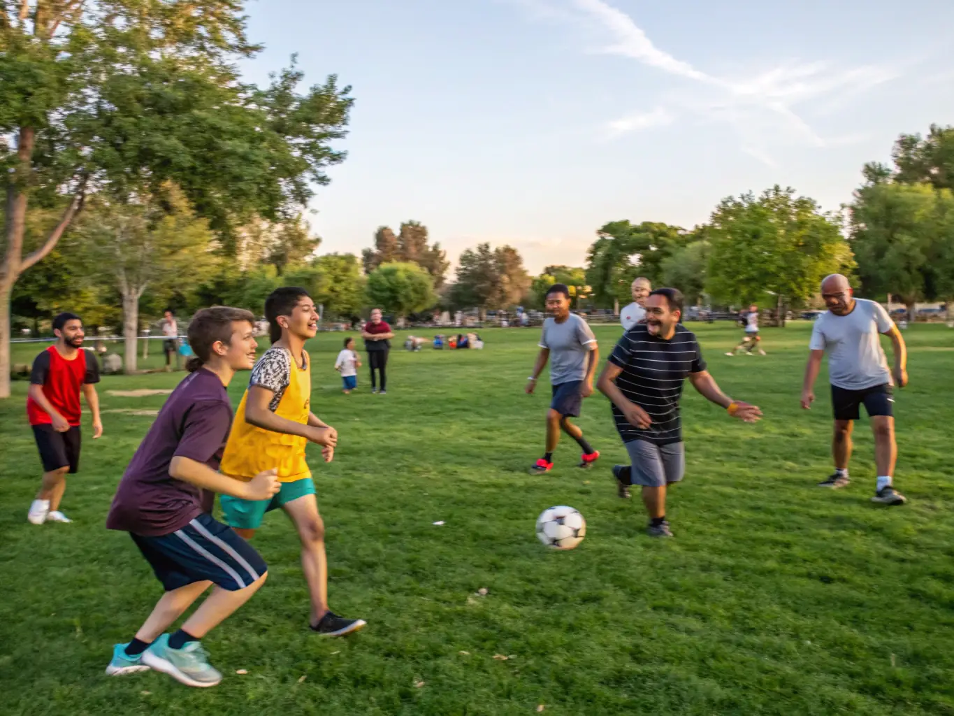 A diverse group of people participating in a community sports event outdoors, illustrating the Social Inclusion Initiatives.